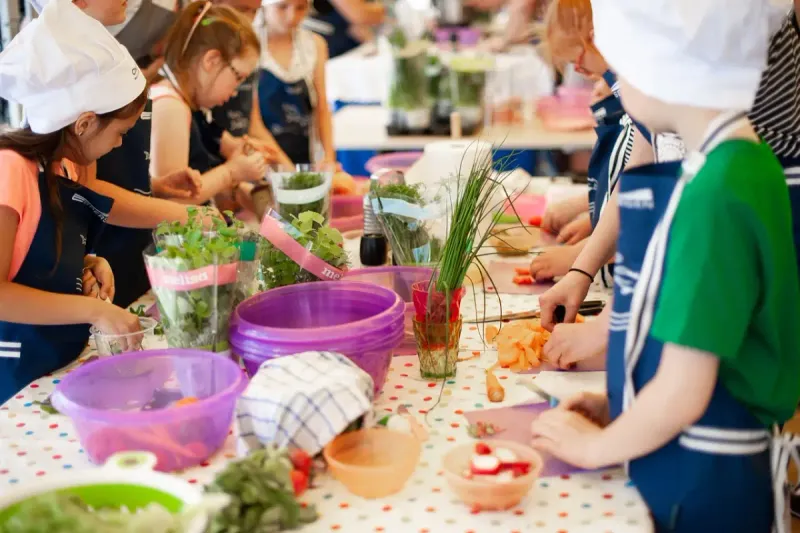 Niños aprendiendo a cocinar en un taller infantil.