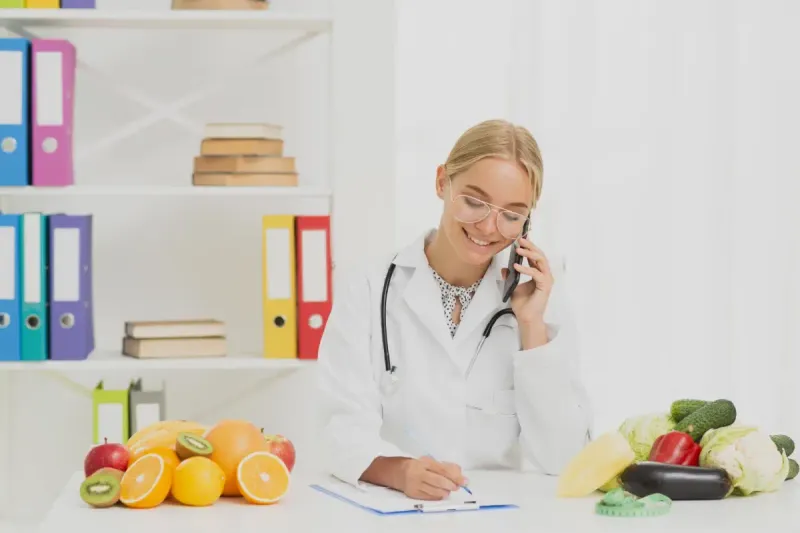 Nutrióloga explicando un plan alimenticio a un paciente en consulta.